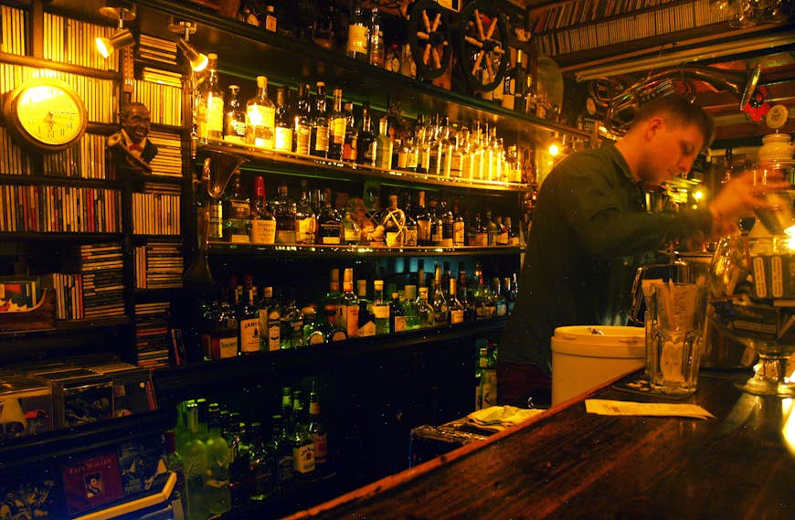 En bartender gör en drink på den svagt upplysta vintagebaren Jazz in Jazz