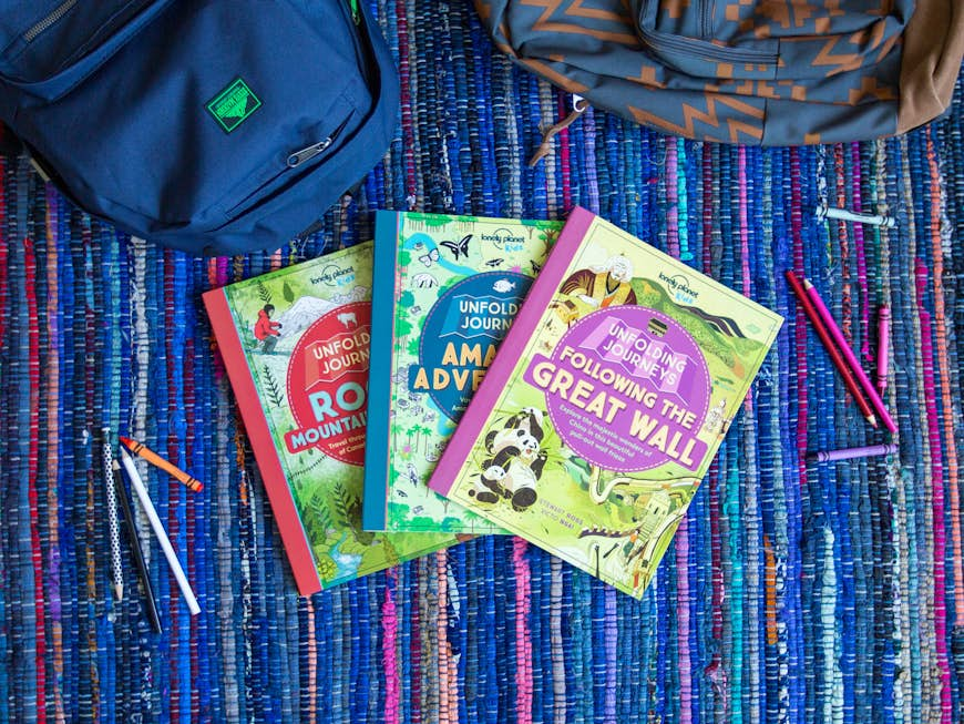 Three Unfolding Journeys books laid out in a fan on a carpet