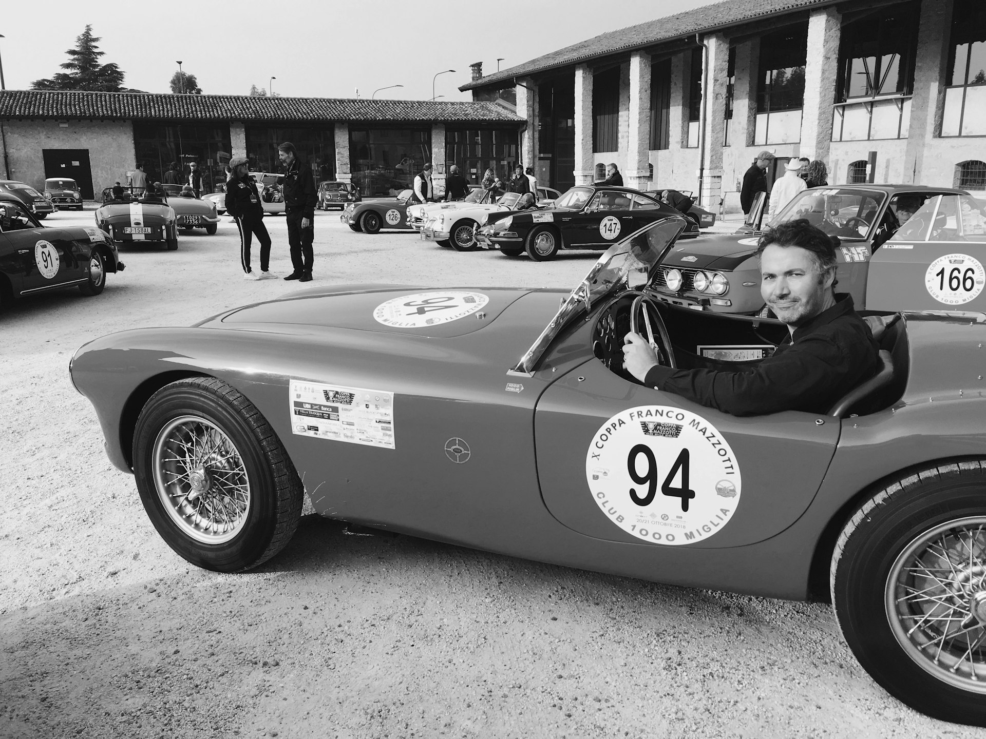 Black-and-white shot of the writer, Peter, sat in a classic sports car