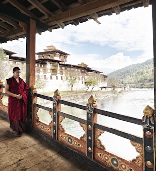 Monk walking on balcony at Punakha Dzong on junction of Pho Chhu and Mo Chhu rivers.