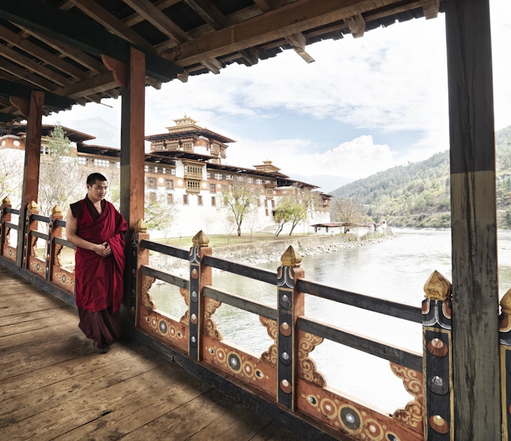 Monk walking on balcony at Punakha Dzong on junction of Pho Chhu and Mo Chhu rivers.