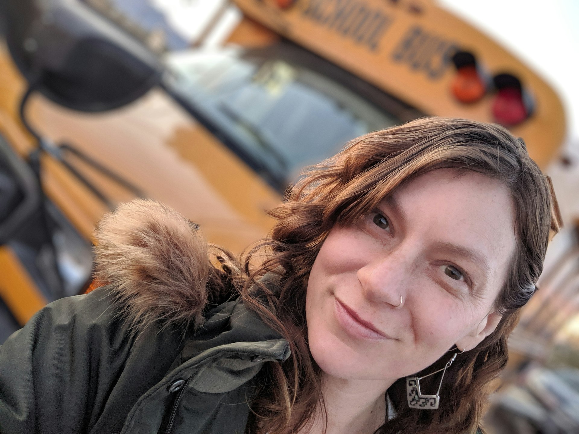 Madeleine poses with a Mona Lisa smile in front of her yellow school bus