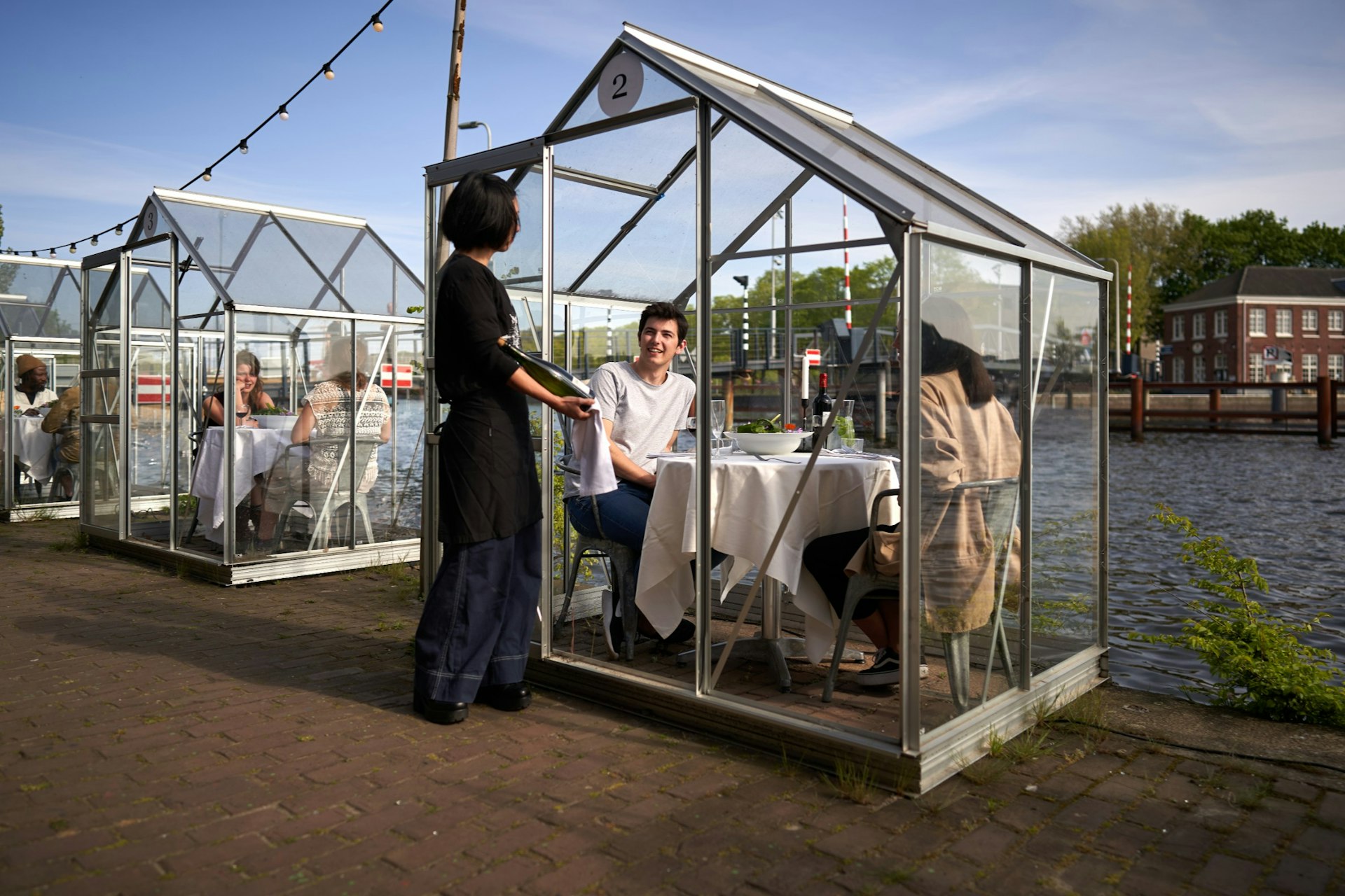 Guests at a restaurant seated inside enclosed glass structures