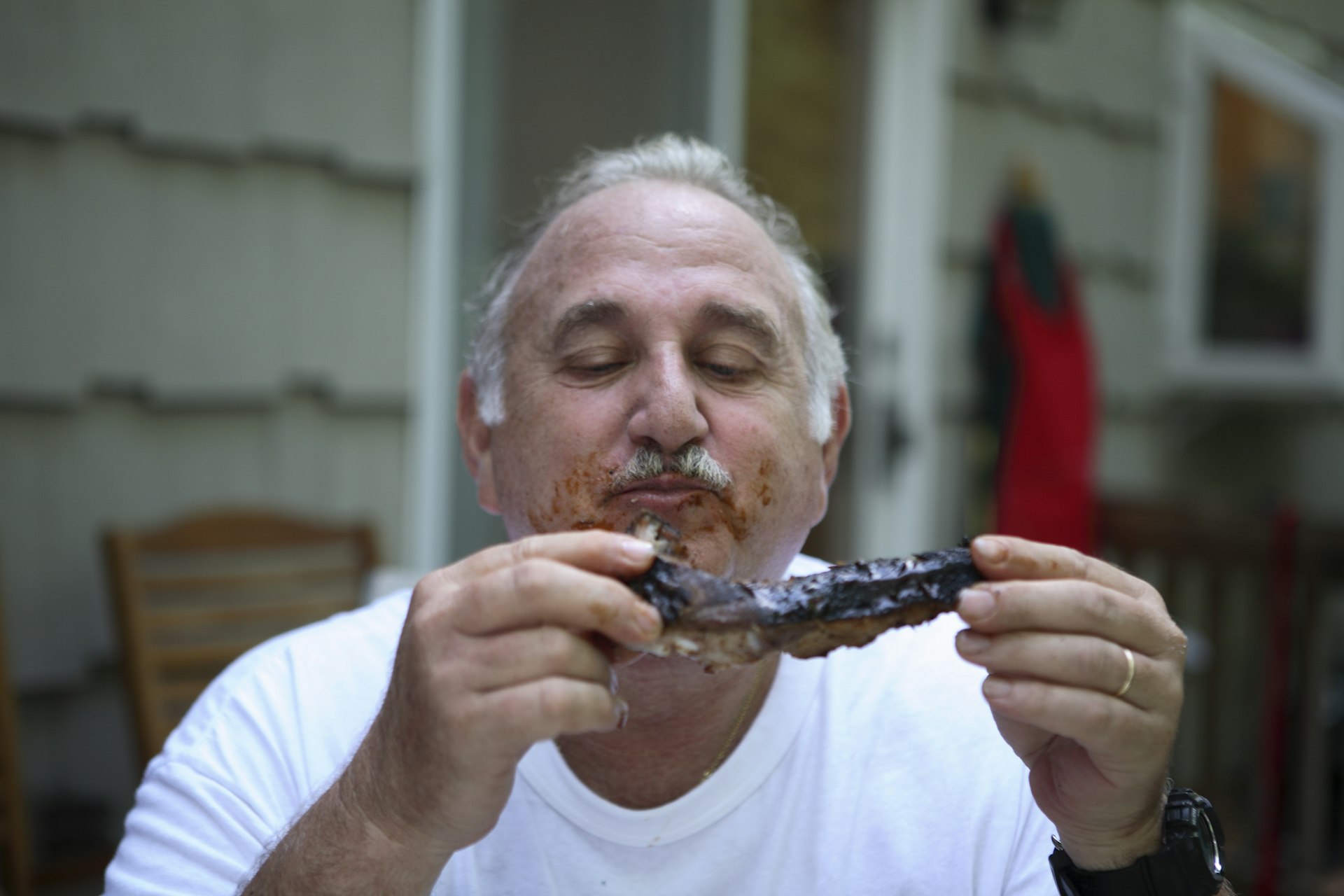 Man messily eating steak covered in sauce