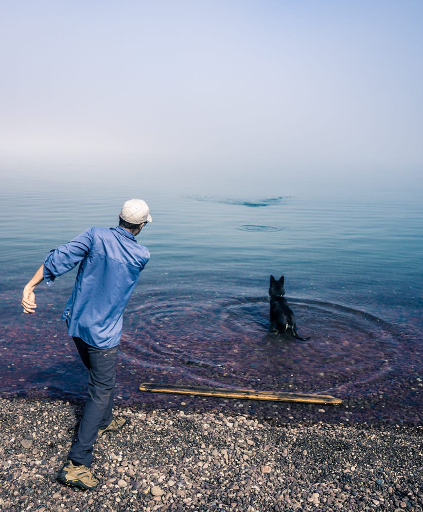 A man and his dog on the shore of Lake Superior, Michigan