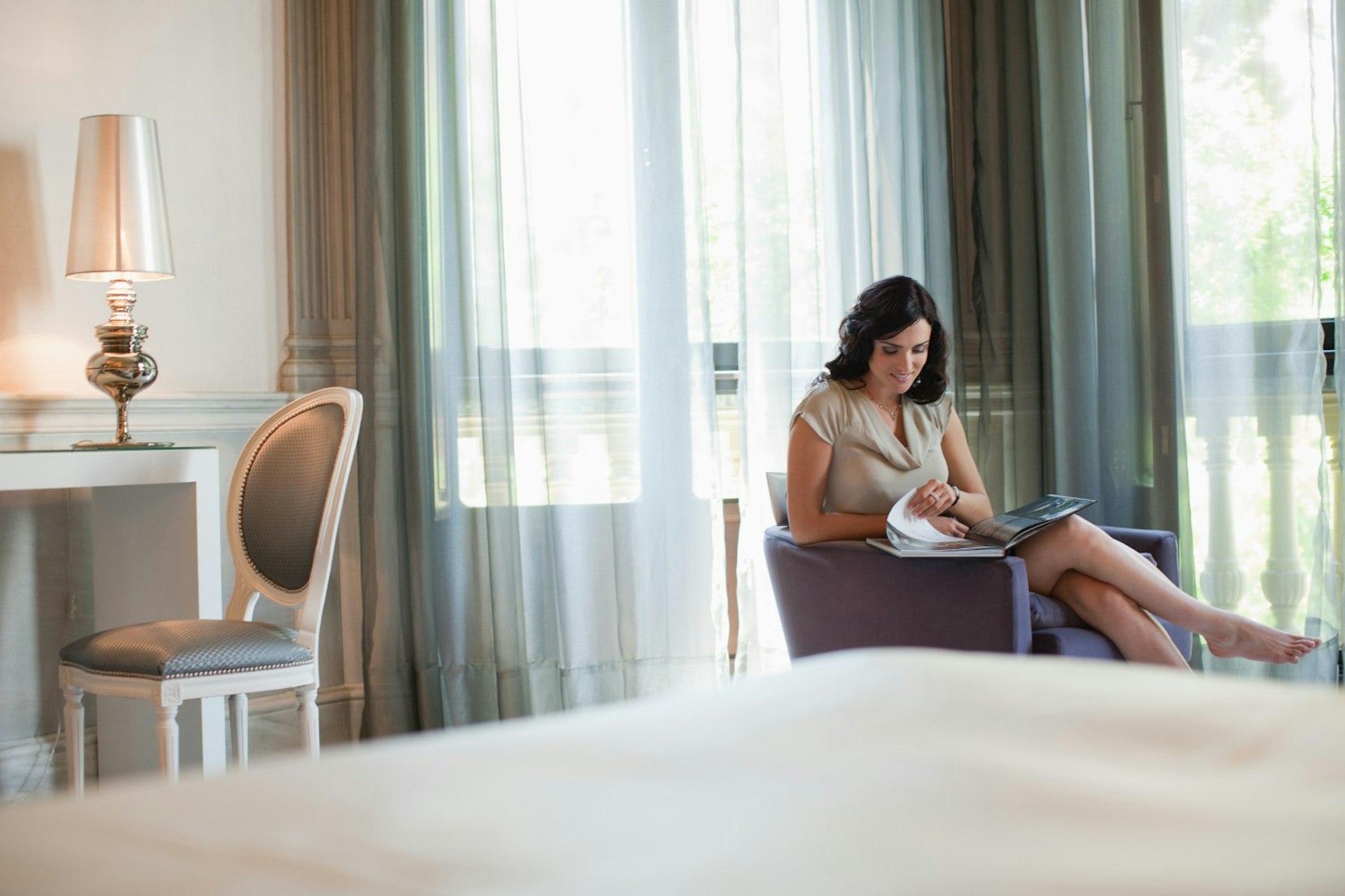 A woman reading a magazine in a hotel room