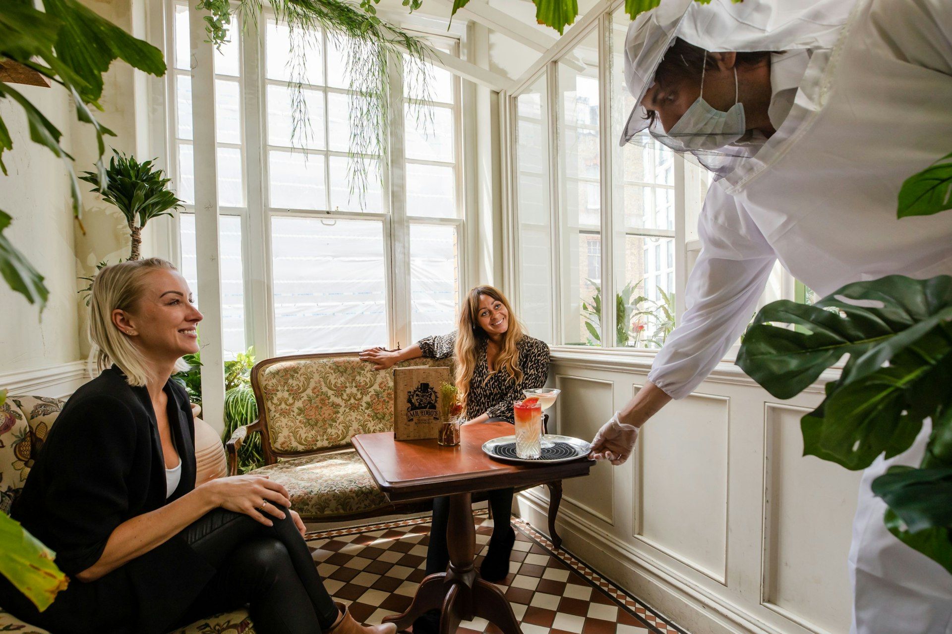 Staff serving customers wearing beekeeper suits at Mr Fogg's House of Botanicals in London