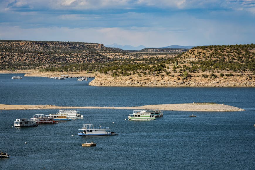 A group of large boats on the lake at Navajo Lake State Park 