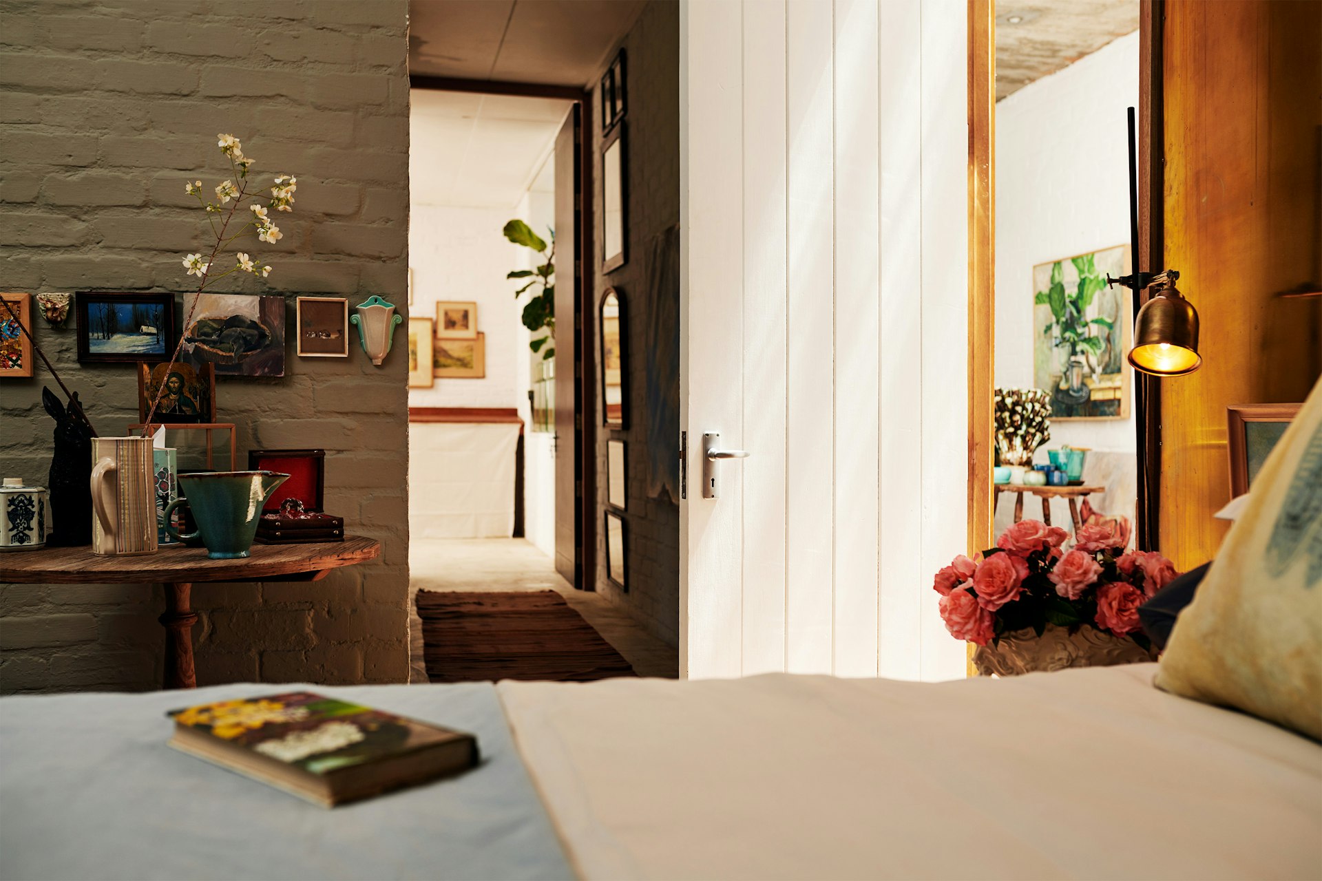 A bedroom with flowers and natural light coming in from the door