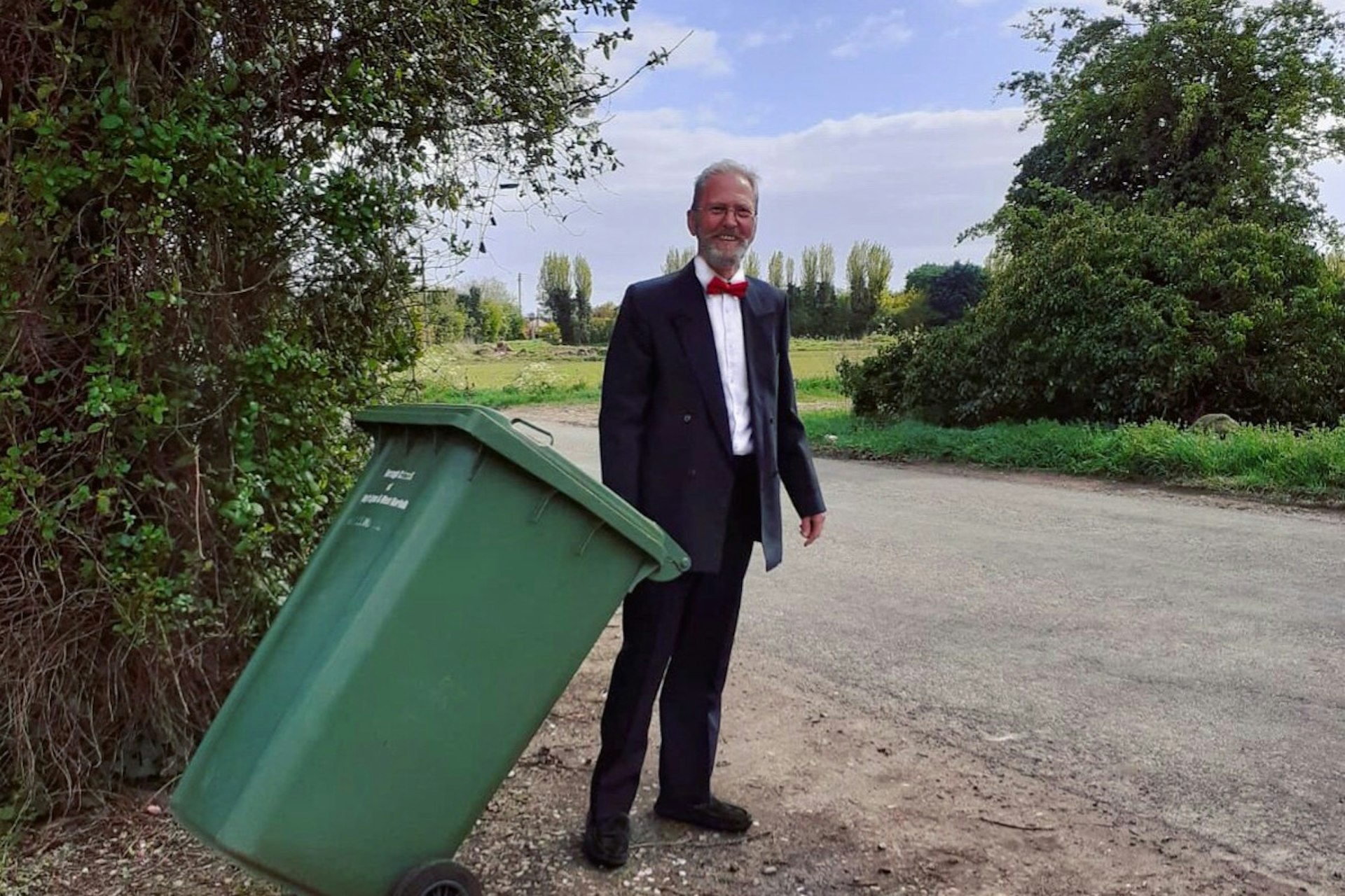 A man in a tuxedo taking out the bin