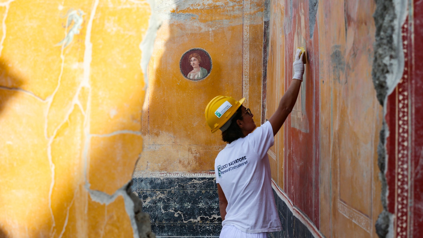 A restorer working on frescos in the House with Garden, a new excavation in the Regio V of the Pompeii excavations.