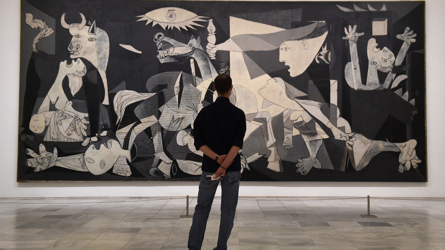 MADRID, SPAIN - JUNE 06: A man looks at Guernica by Pablo Picasso during the partial reopening of the Reina Sofia Museum, after its closure in March due to the Covid-19 pandemic, on June 06, 2020 in Madrid, Spain. A maximum of 30 people (30%) at a time are now allowed to view Picasso's iconic anti-war painting depicting the 1937 bombing of the Basque town of Guernica during the Spanish civil war.   (Photo by Denis Doyle/Getty Images)