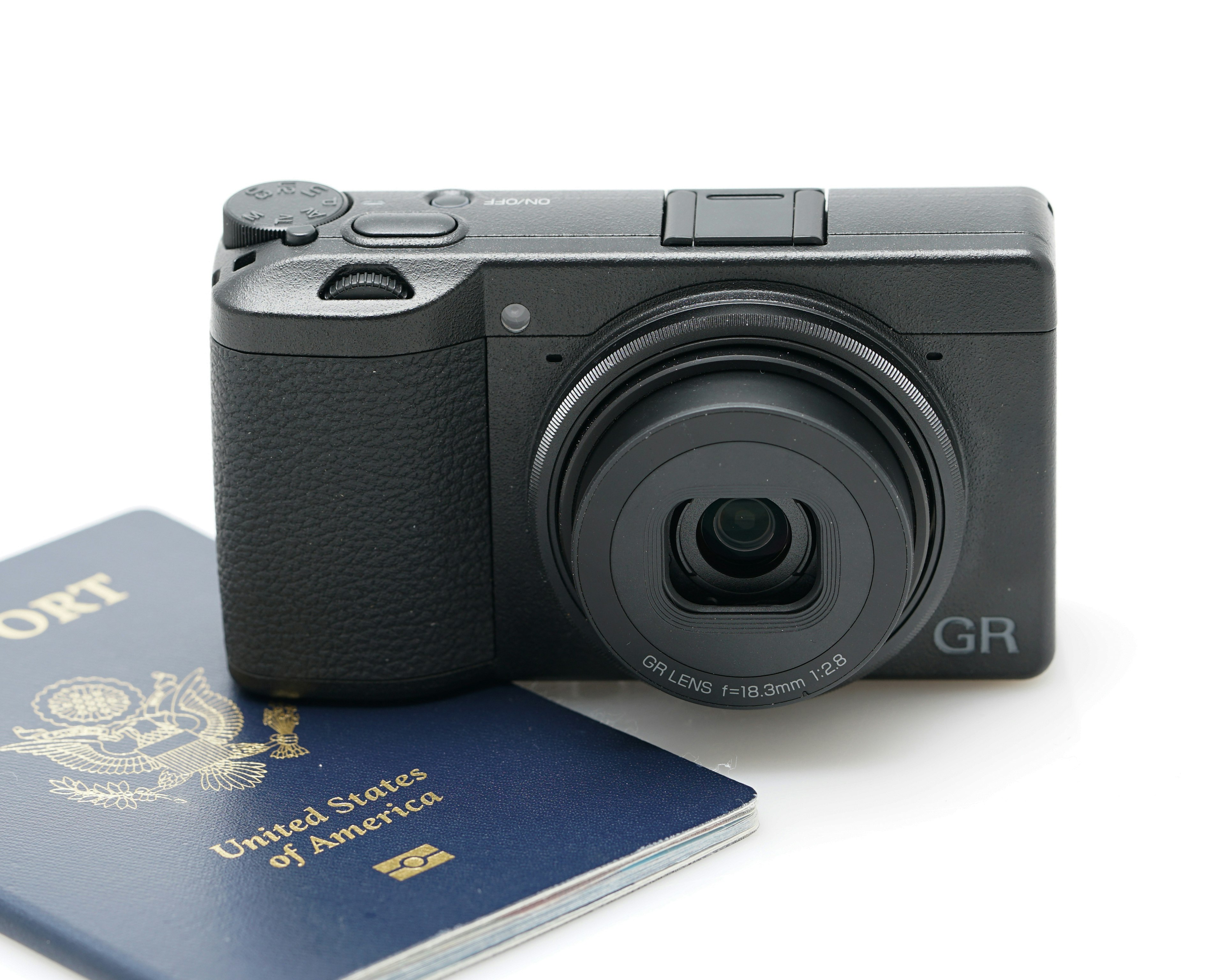 Product shot of the Ricoh GRIII and a passport.