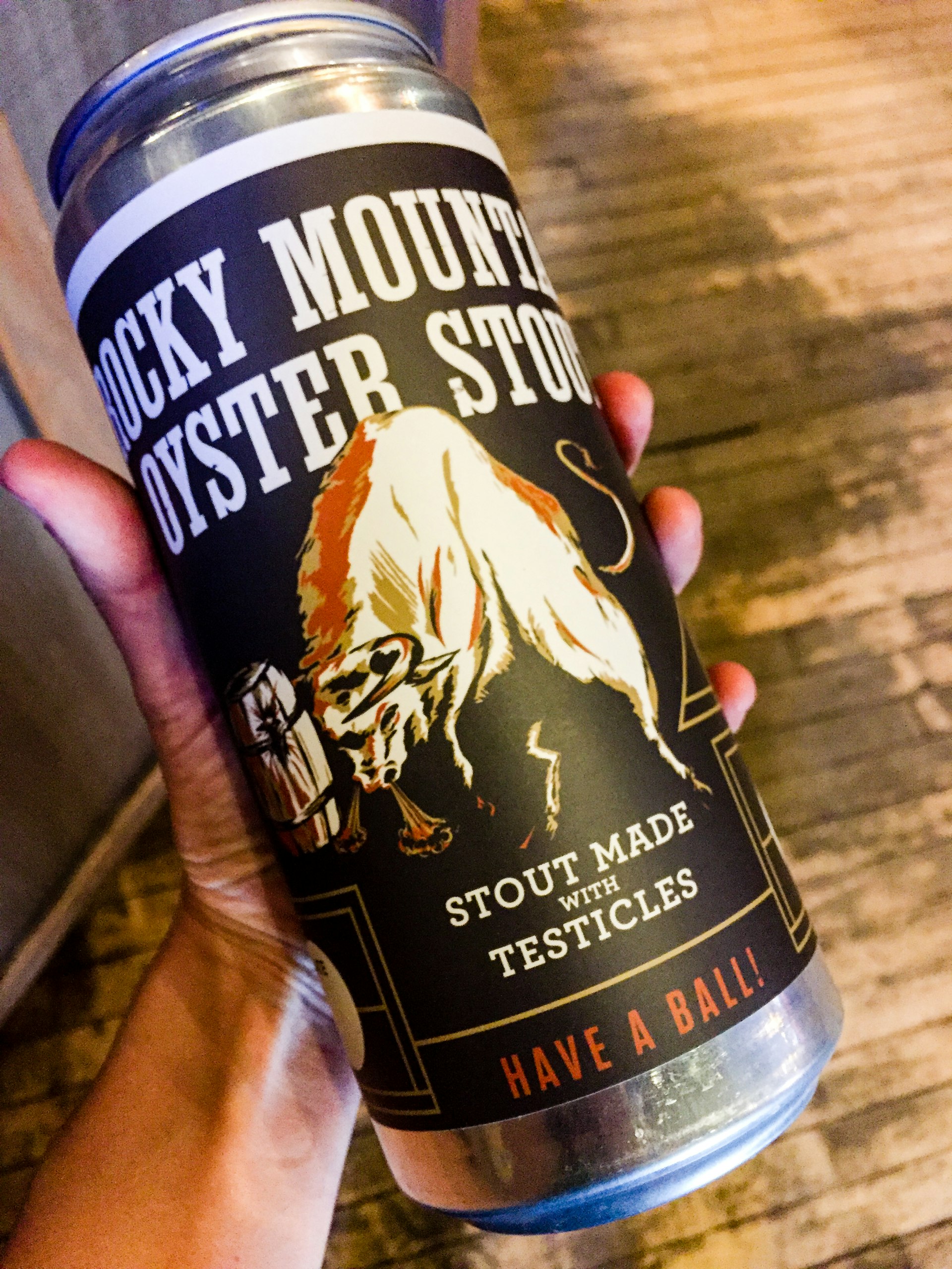 A hand holds a can of Rocky Mountain Oyster Stout