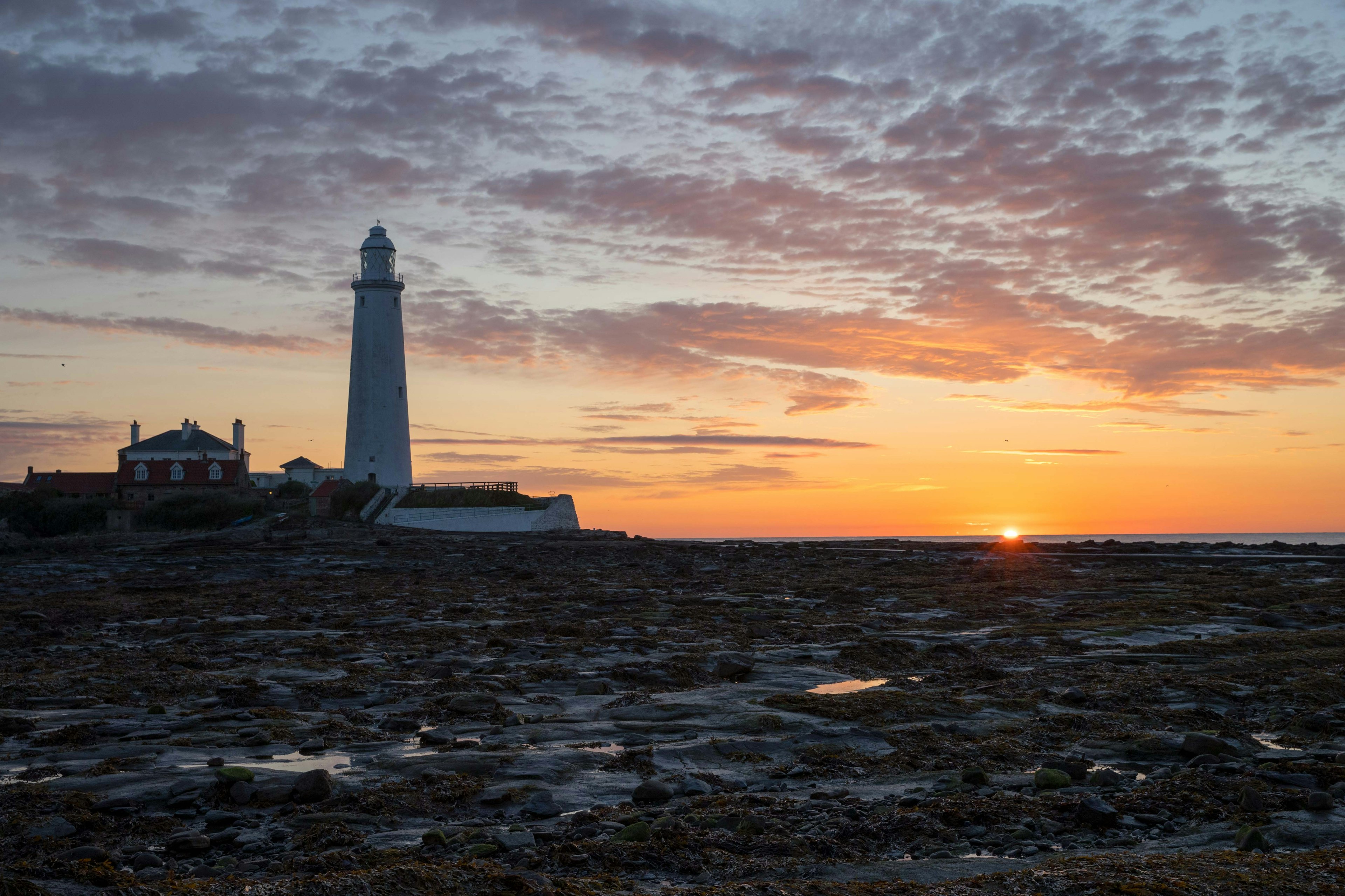 A lighthouse against a sunrise