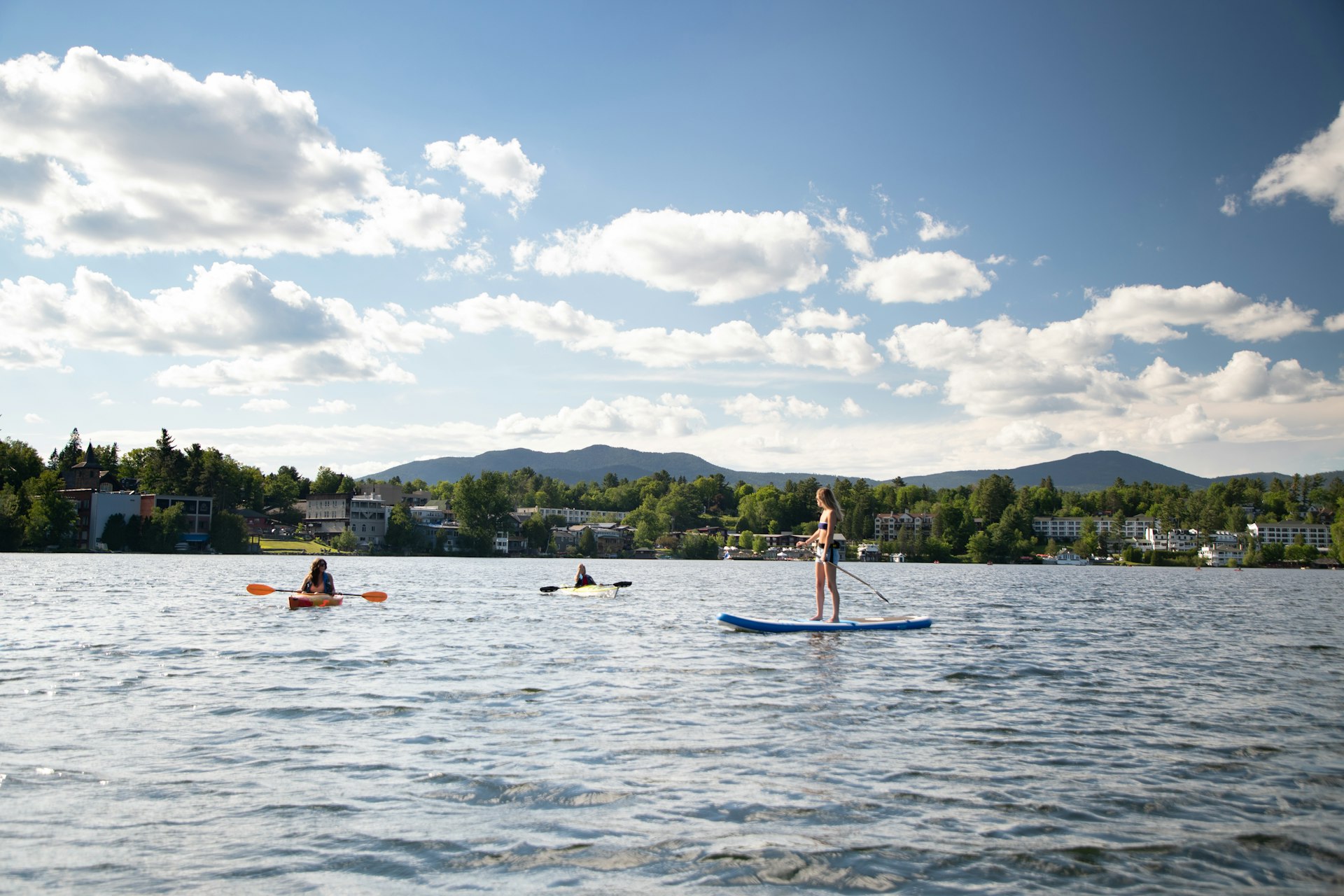 Stand-up paddleboarders on Mirror Lake, in New York's Adirondack Mountains