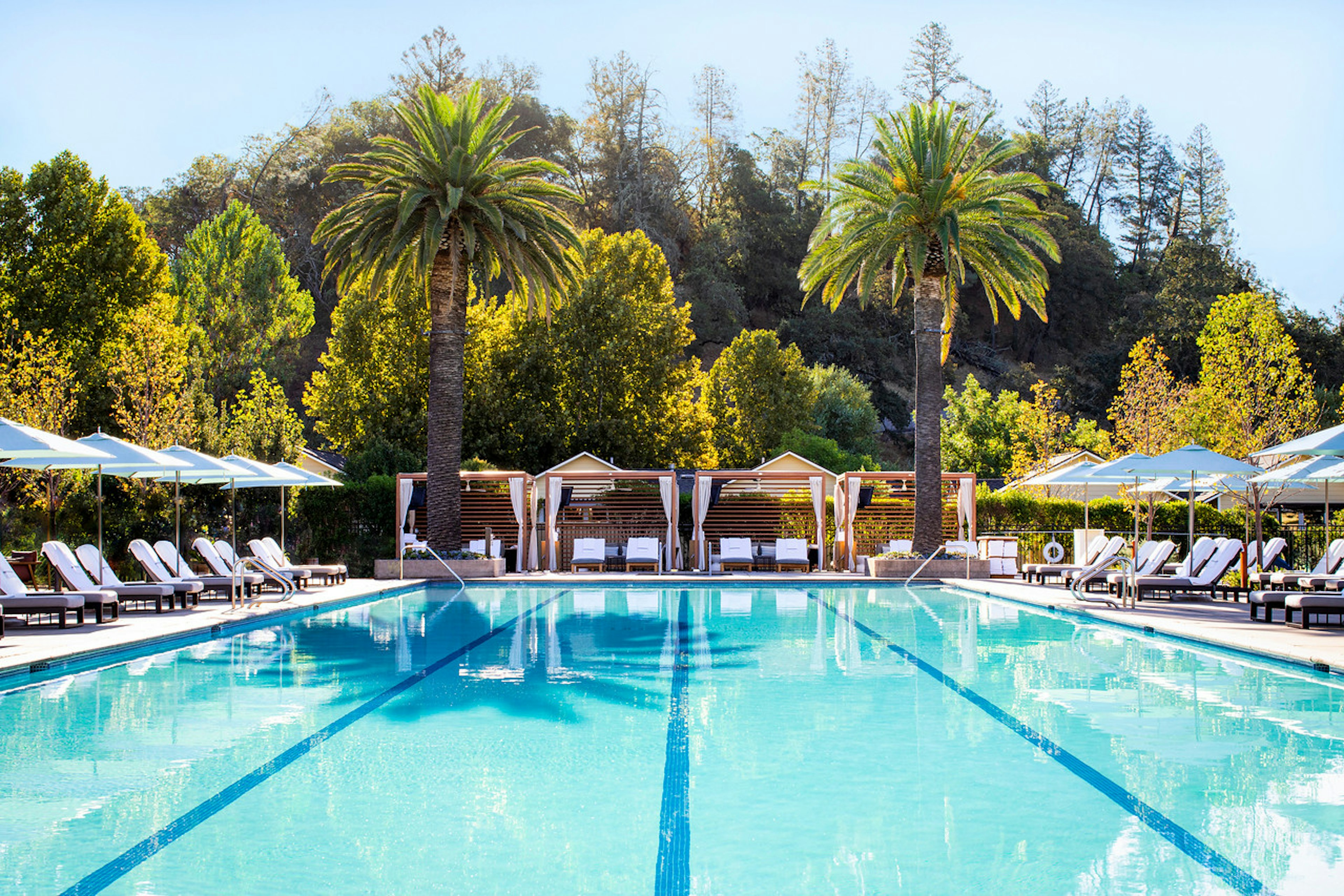 An empty pool with lounge chairs on a sunny day