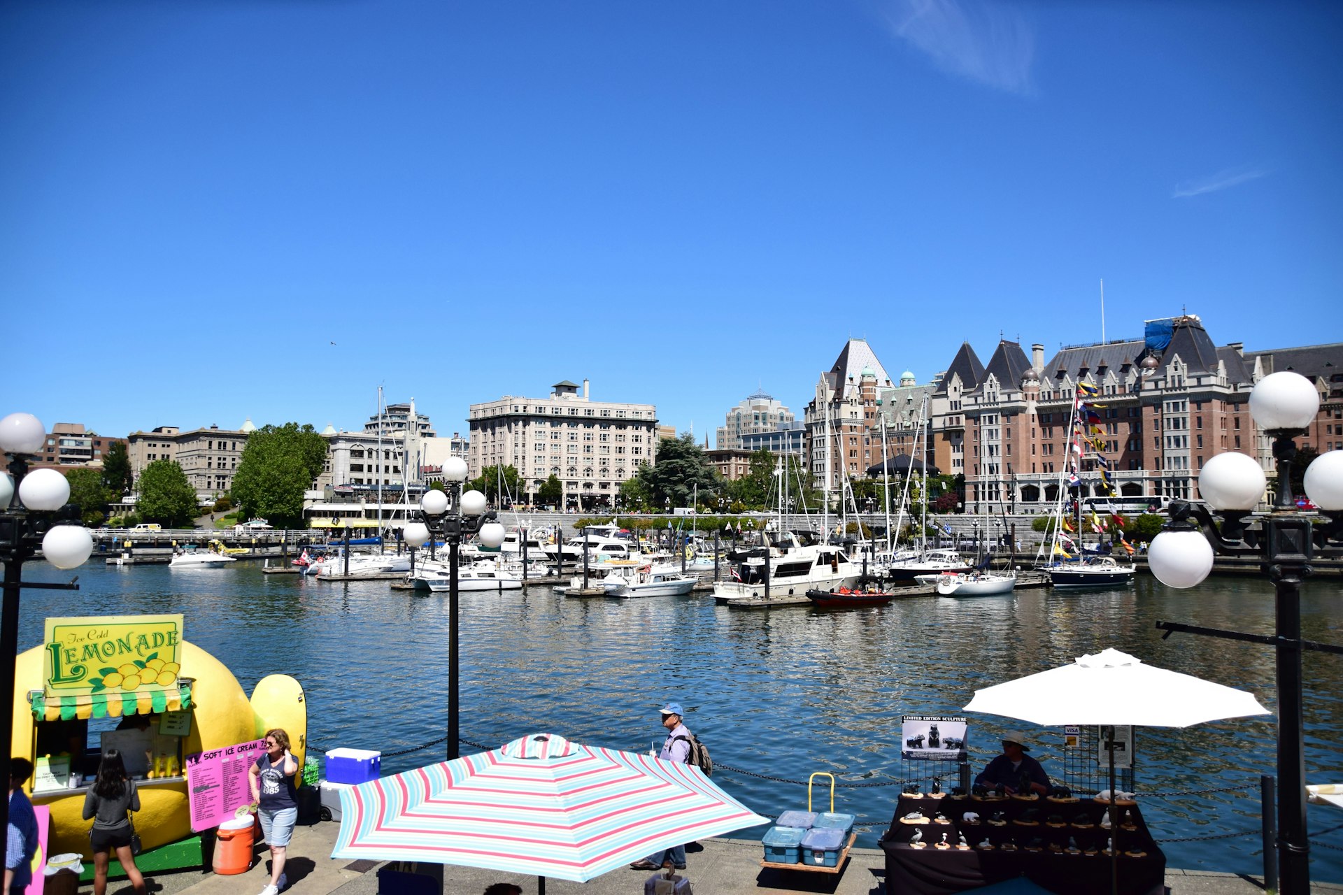 A pretty marina lined with a few small boats. People mill about at the water's edge