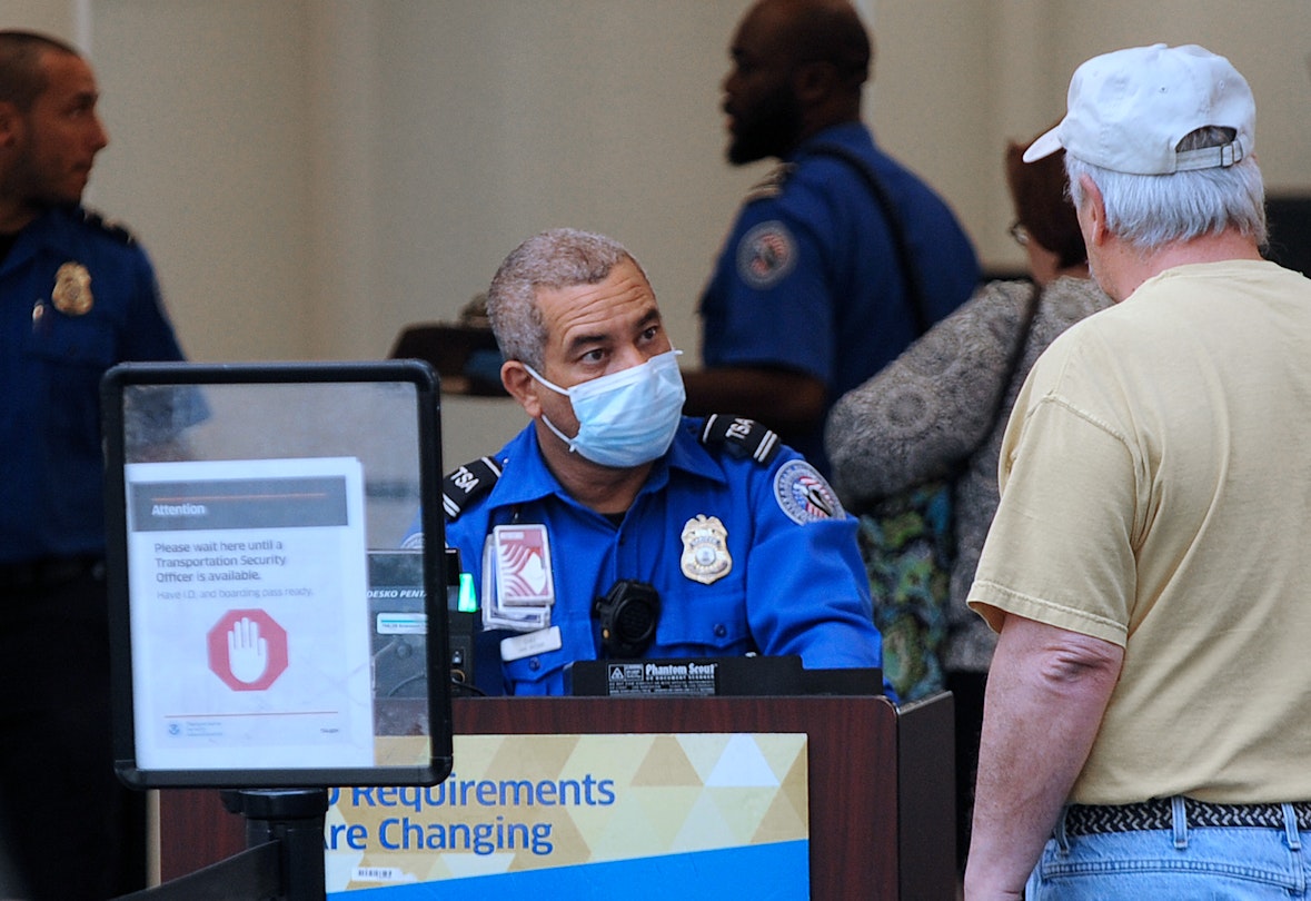 ORLANDO, FLORIDA, UNITED STATES - APRIL 2, 2020: A TSA officer wears a protective mask while screening travellers at Orlando International Airport. In the past 14 days across the nation, 58 TSA screening officers have tested positive for COVID-19, including 9 in Orlando.- PHOTOGRAPH BY Paul Hennessy / Echoes Wire/ Barcroft Studios / Future Publishing (Photo credit should read Paul Hennessy / Echoes Wire/Barcroft Media via Getty Images)