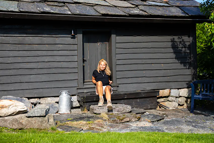 The Discovery Route barn.jpg Woman sitting outside a traditional Norwegian barn