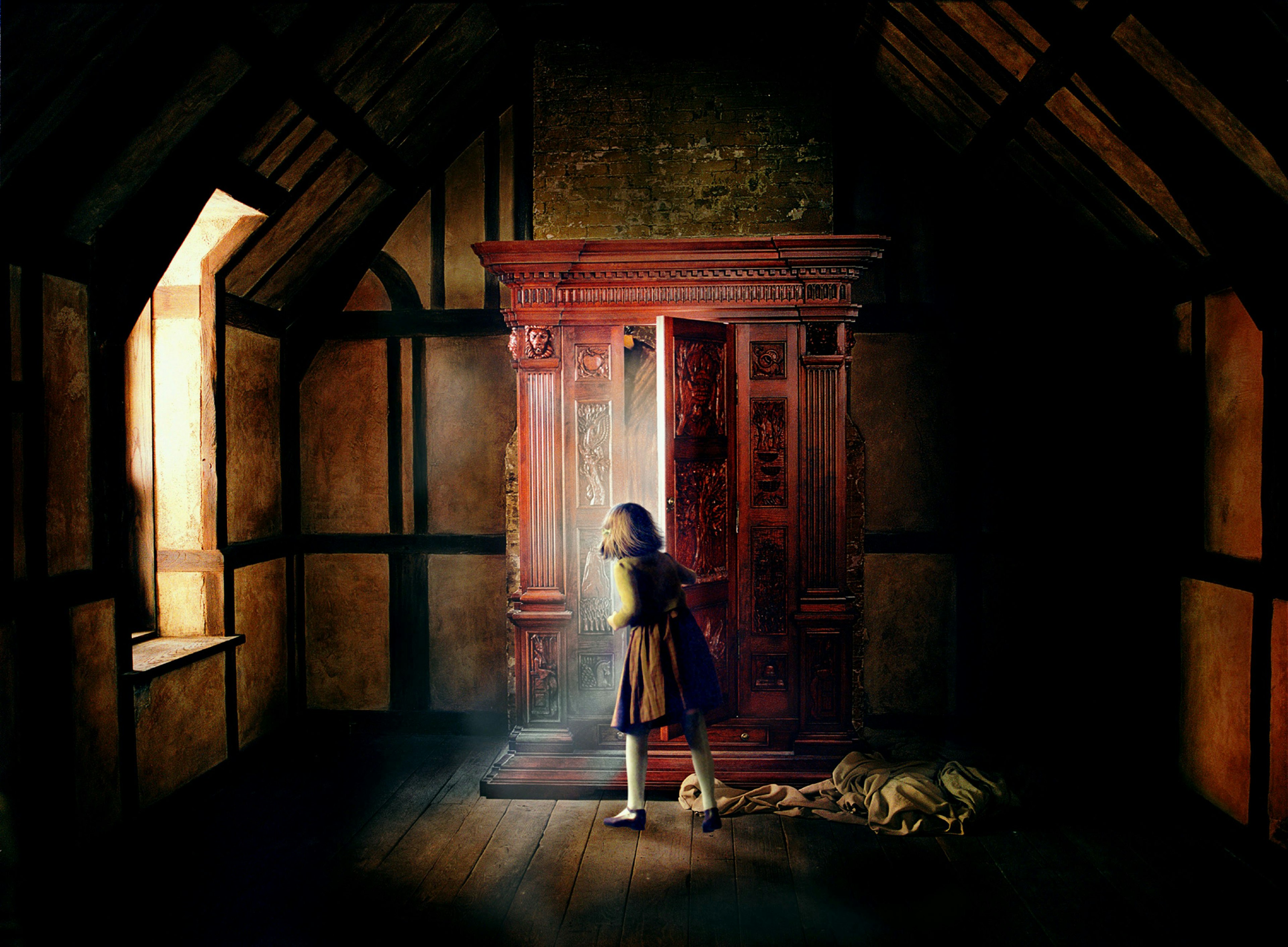 A little girl opens a wardrobe in The Chronicles of Narnia