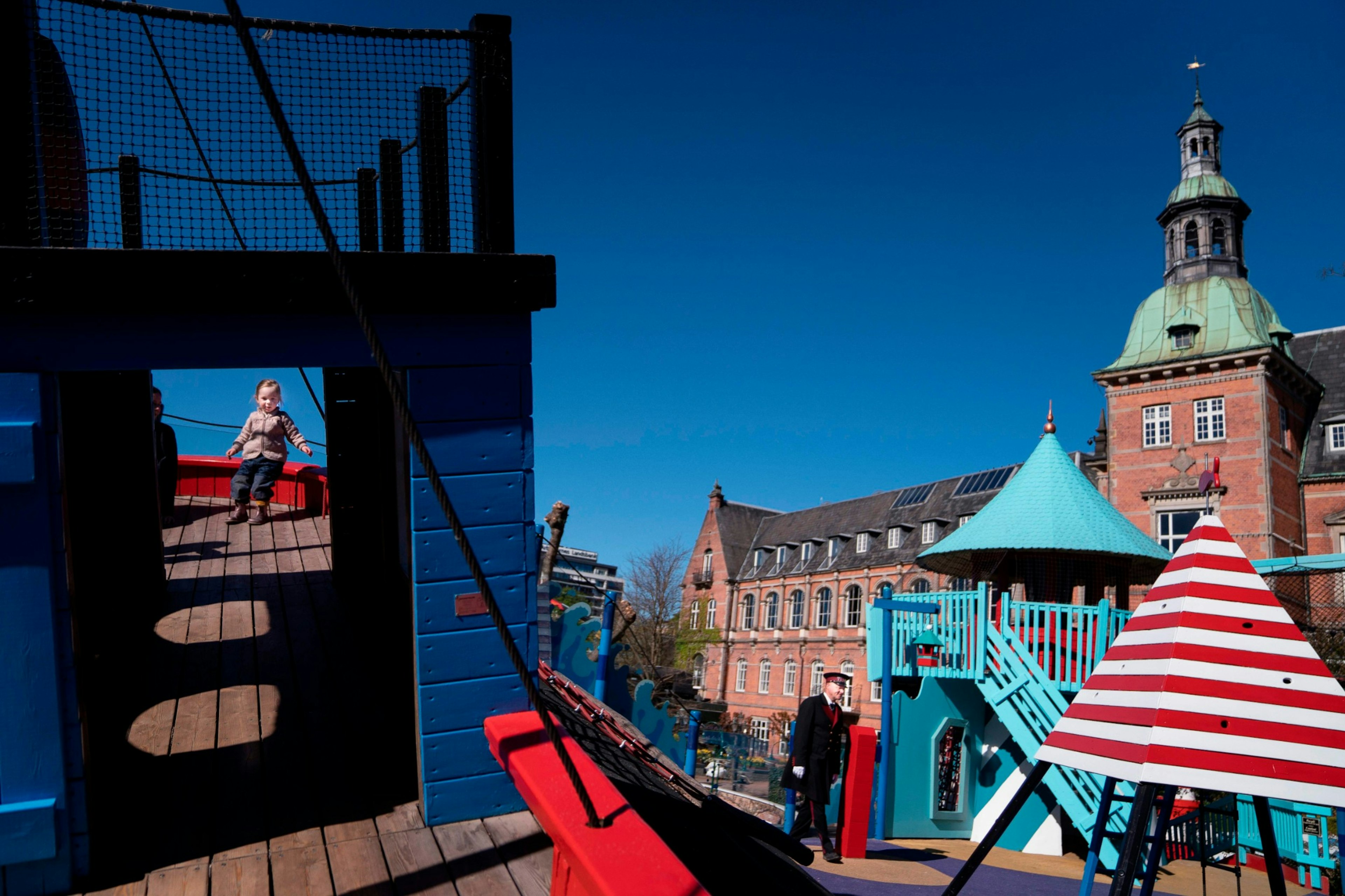 Children playing in Tivoli Gardens while an attendant looks on