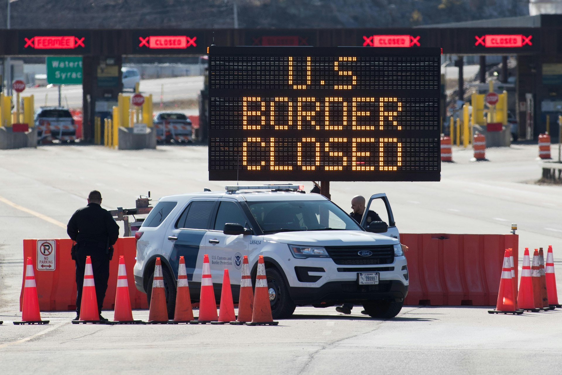 US Customs officers stand beside a sign saying that the US border is closed at the US/Canada border in Lansdowne, Ontario