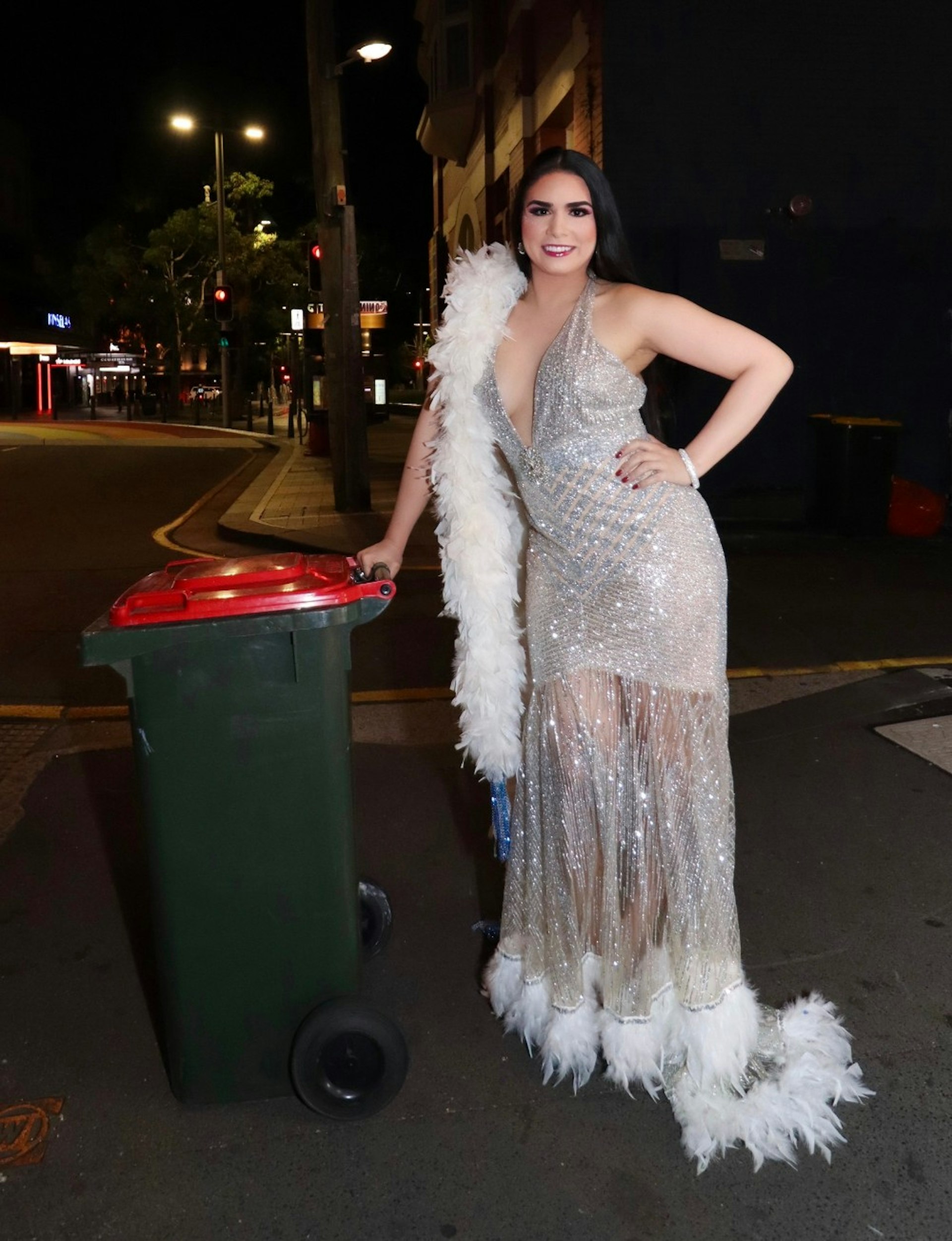 A woman in glam dress putting out her bin