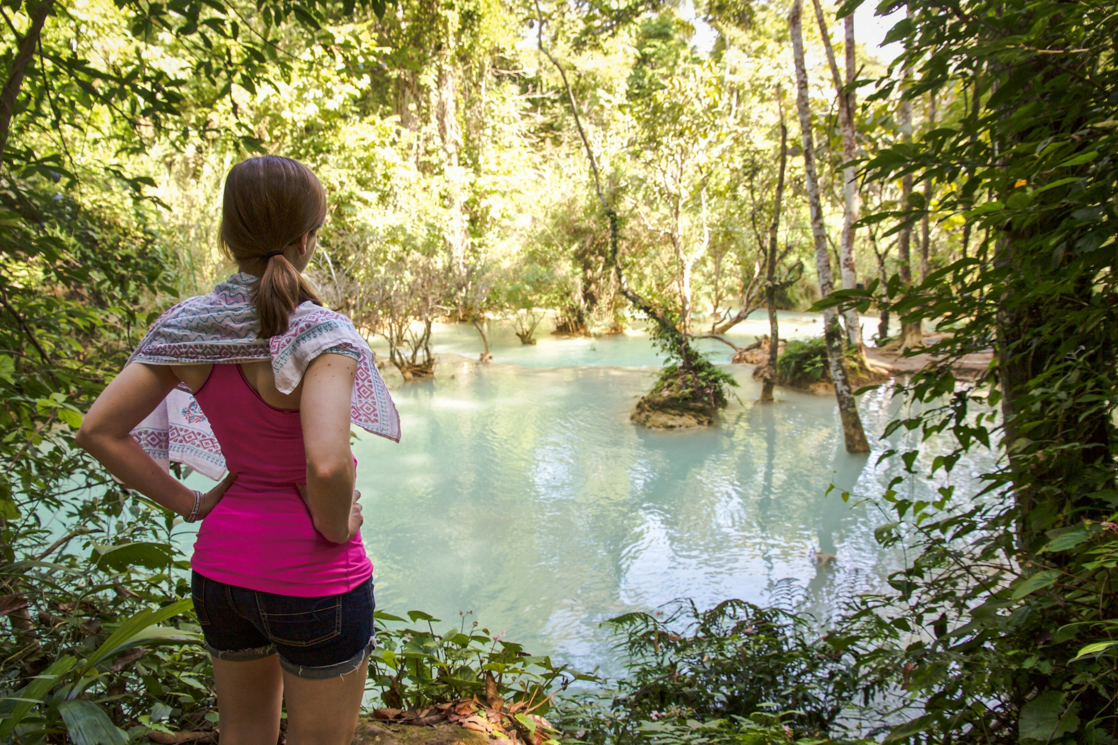 A woman standing looking at a waterfall