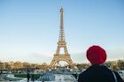 France, Paris, view to Eiffel Tower with back view of young woman standing in the foreground