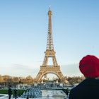 France, Paris, view to Eiffel Tower with back view of young woman standing in the foreground