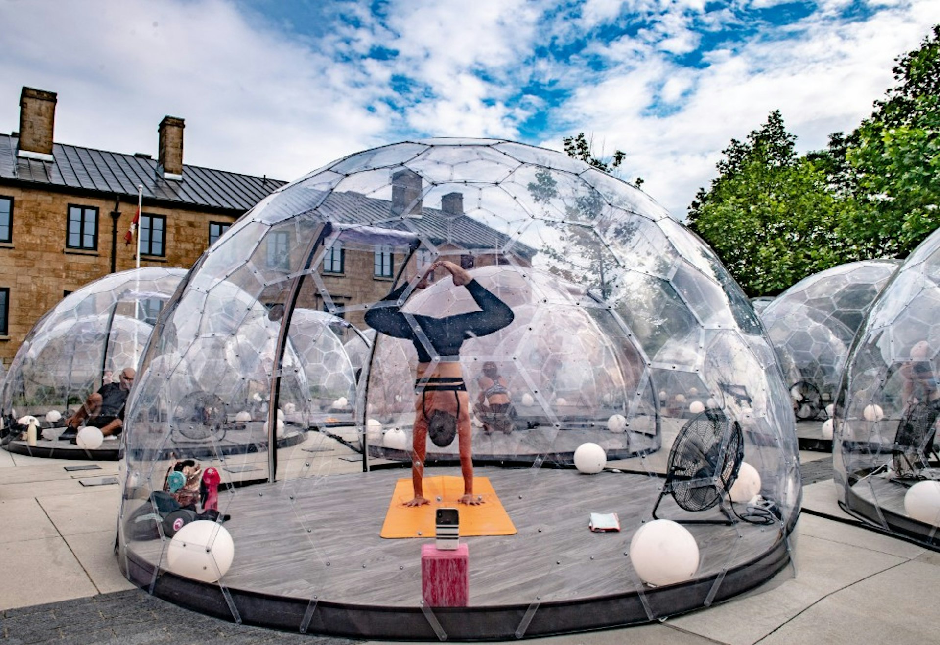 A woman doing yoga in a bubble on the street