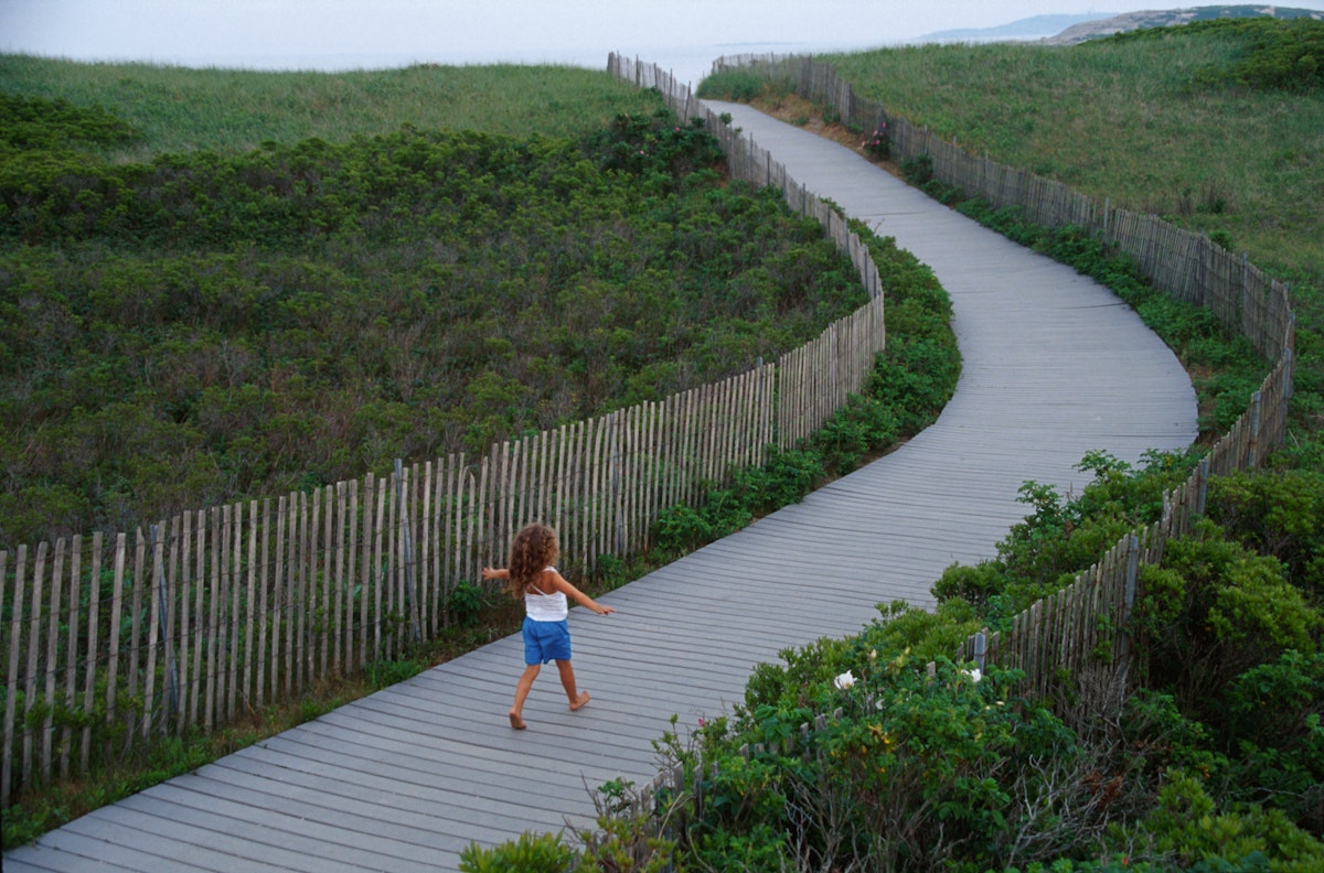 A child walking on the boardwalk over natural dune, Popham Beach State Park, Maine. (Photo by: Jeffrey Greenberg/Universal Images Group via Getty Images)