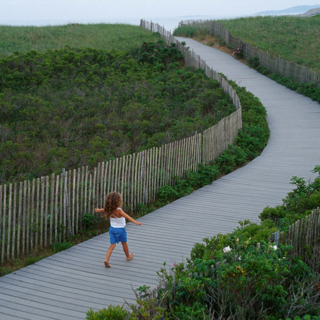 A child walking on the boardwalk over natural dune, Popham Beach State Park, Maine. (Photo by: Jeffrey Greenberg/Universal Images Group via Getty Images)