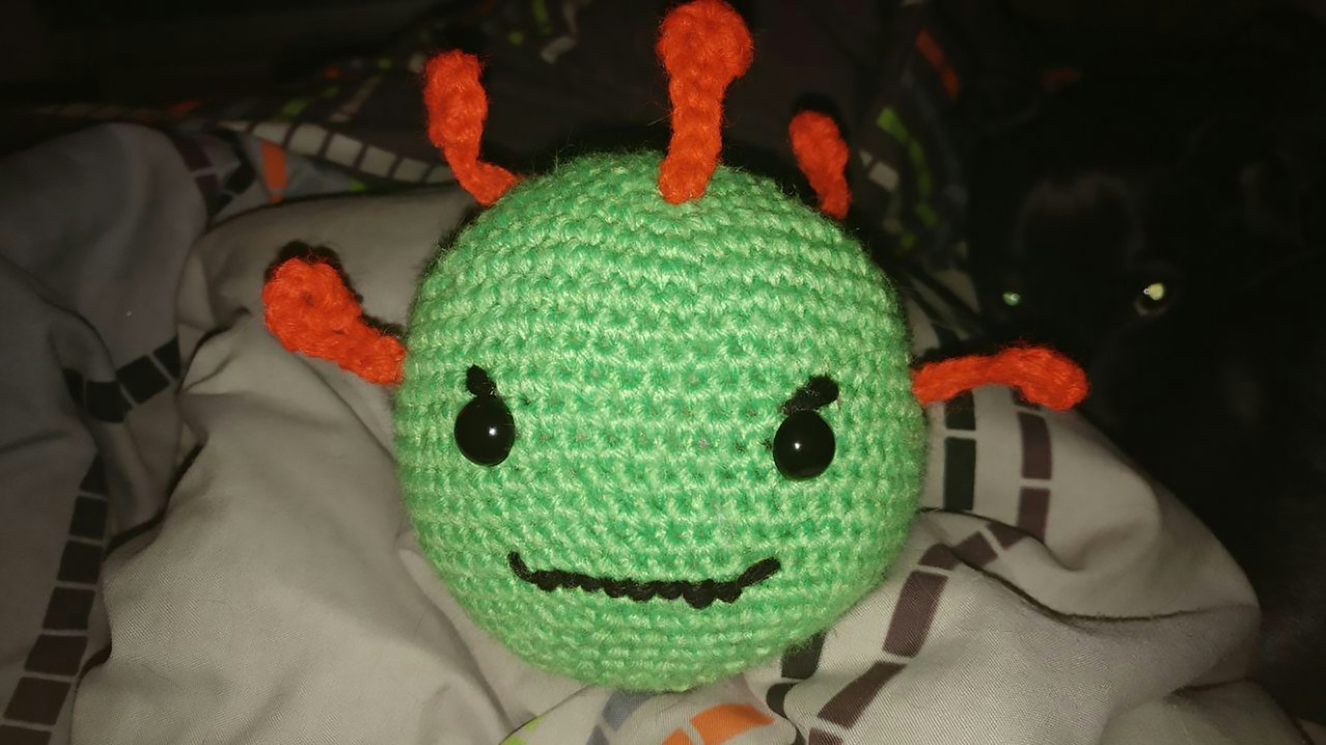 A picture of a crocheted plushie of a coronavirus molecule