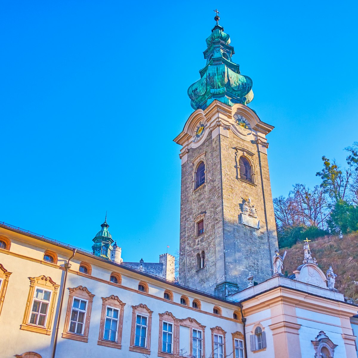 The mighty bell tower of the Collegiate Church of Abbey of St.Peter complex with greenery of Monchsberg hill on the background, Salzburg, Austria; Shutterstock ID 1478477327; Your name (First / Last): Lauren Vastine; GL account no.: 65050; Netsuite department name: Online Editorial; Full Product or Project name including edition: BiT2020 Imagery