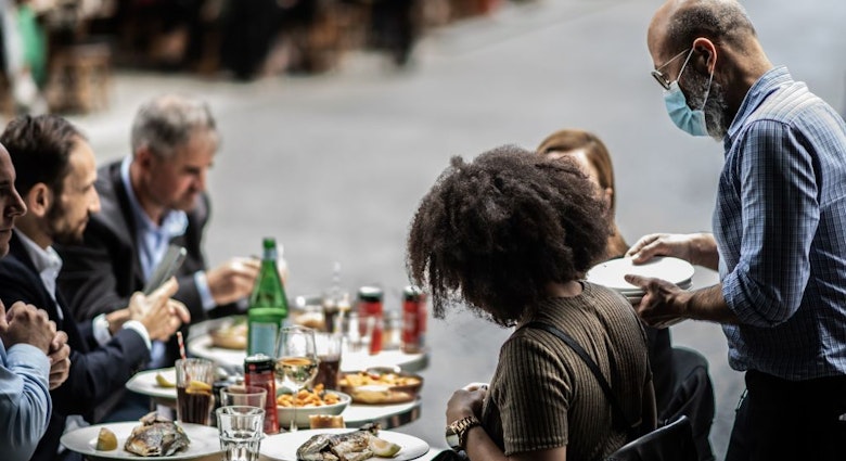 A waiter serves customers at a terrace of a restaurant in Paris, on June 15, 2020, as cafes and restaurants are allowed to serve customers inside, as well as on terraces, as part of the easing of lockdown measures taken to curb the spread of the COVID-19 pandemic, caused by the novel coronavirus. (Photo by Martin BUREAU / AFP) (Photo by MARTIN BUREAU/AFP via Getty Images)