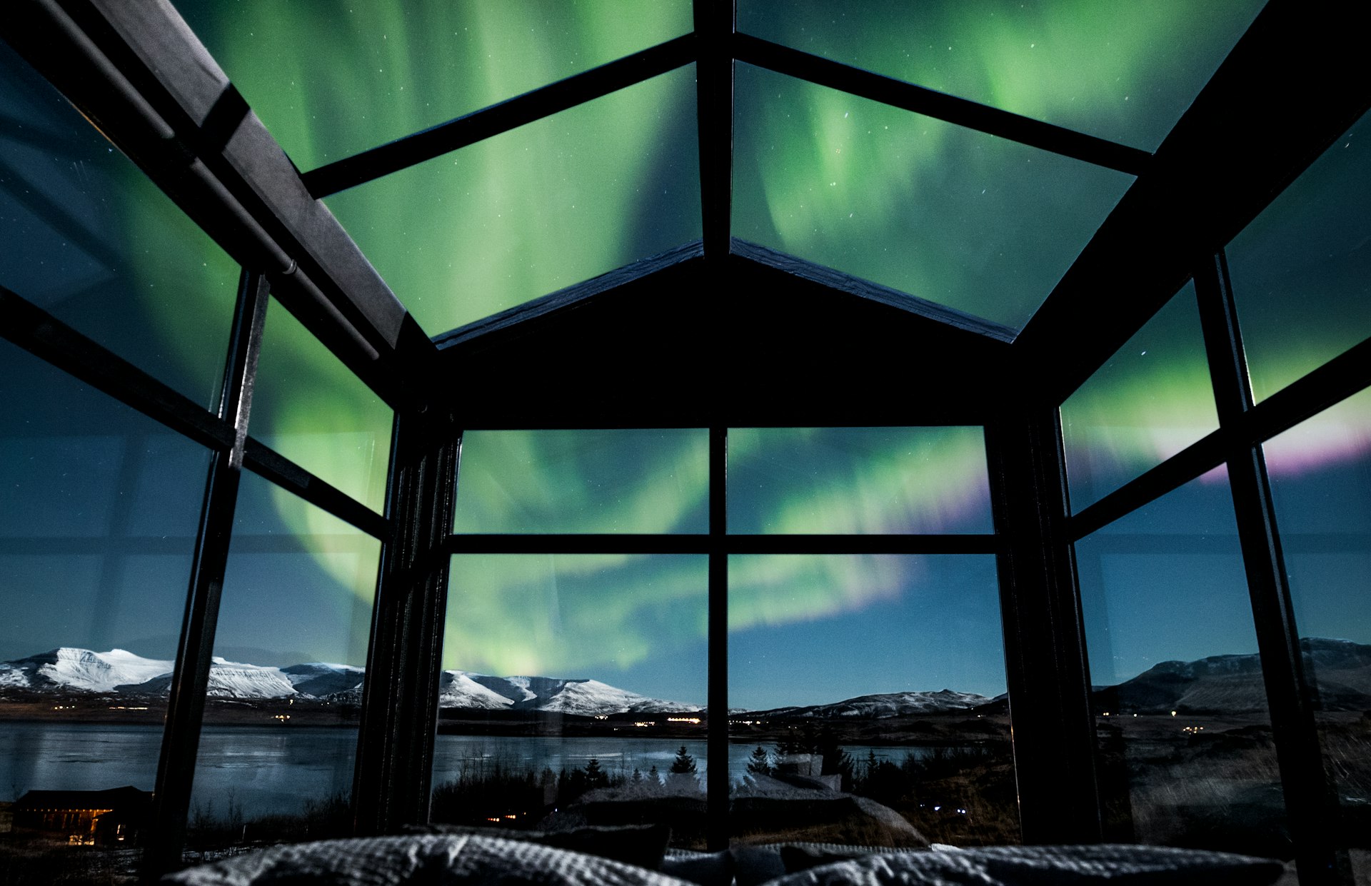A picture of the Northern Lights through the glass ceiling of the cabin