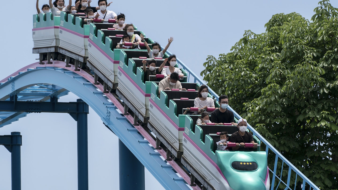 UTSUNOMIYA, JAPAN - MAY 17: Visitors wearing face masks ride a roller coaster at the Tochinoki Family Land amusement park on May 17, 2020 in Utsunomiya, Tochigi, Japan. Japan's Prime Minister Shinzo Abe announced on May 14 that the nationwide state of emergency has been lifted for 39 of the country's 47 prefectures after the number of new Covid-19 coronavirus cases decreased. However, Hokkaido, Tokyo, Kanagawa, Saitama, Chiba, Osaka, Kyoto and Hyogo will remain under the order until May 31.  (Photo by Tomohiro Ohsumi/Getty Images)