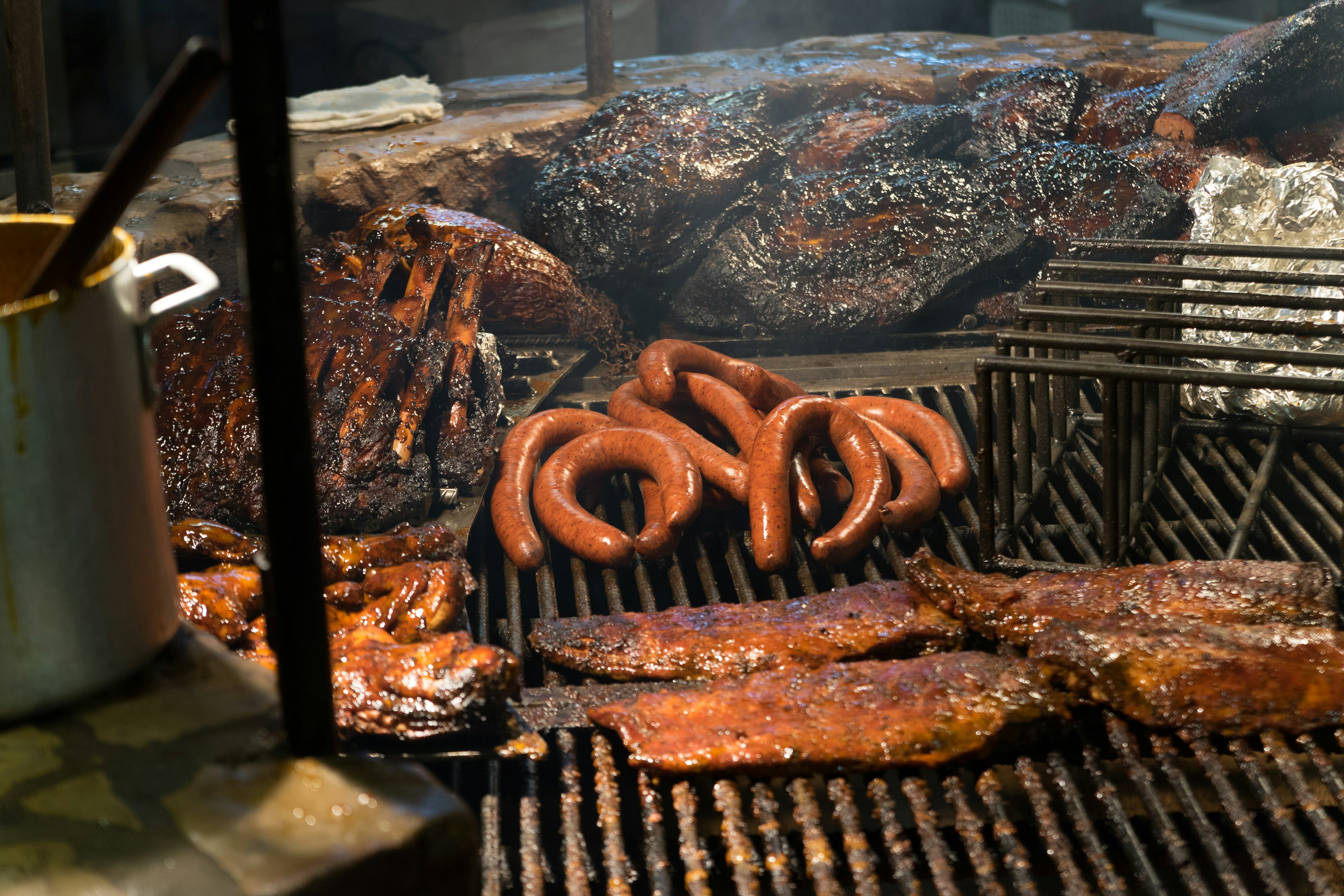 Texas style bbq, pit smoked ribs with sauce over wood fire flame.