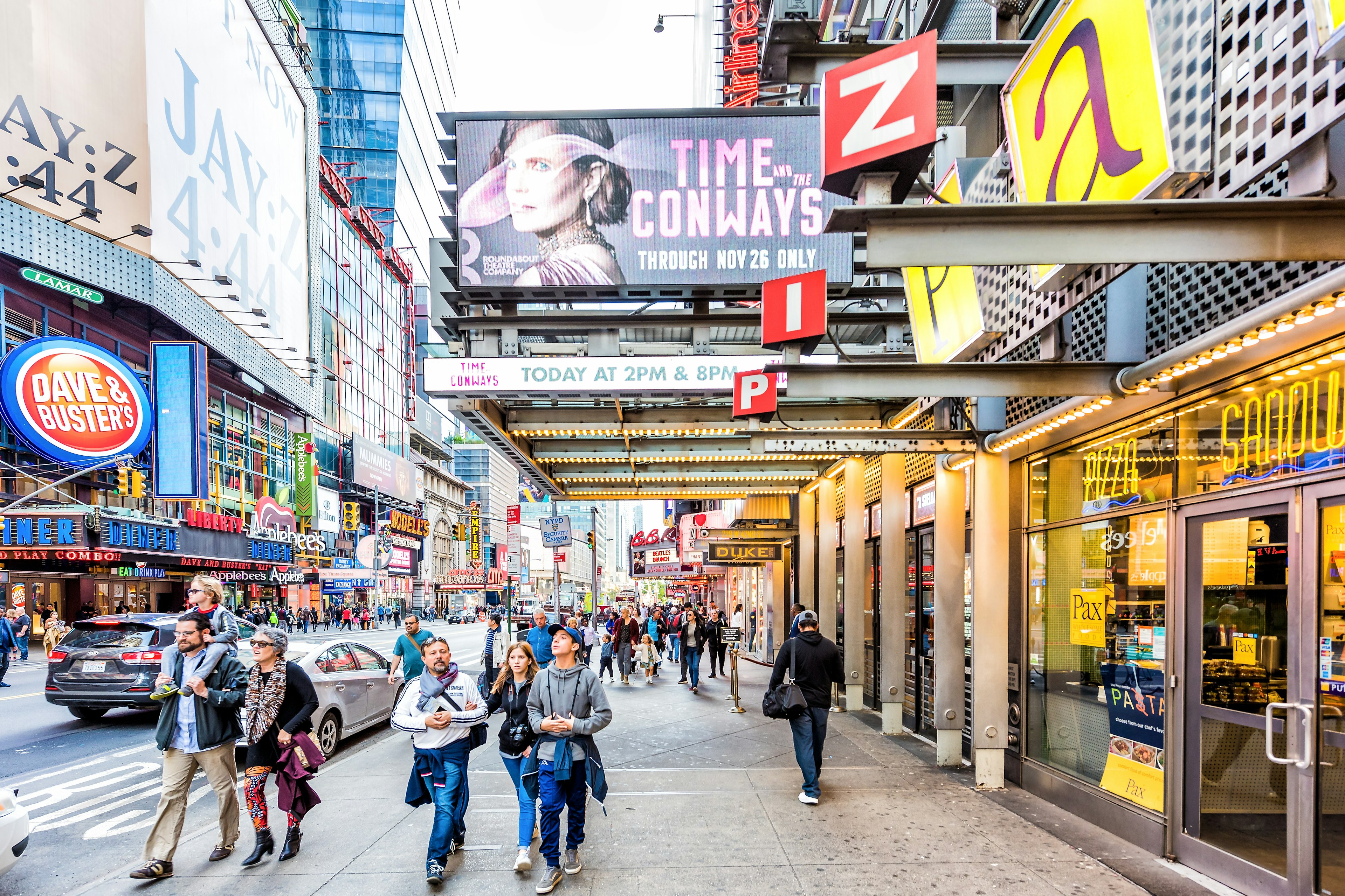 Pedestrians walk along the heavily signed 42nd street