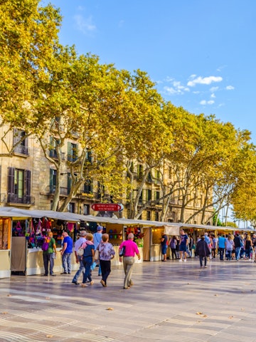 OCTOBER 26, 2014: People walking past market stalls on the La Rambla street in Barcelona.