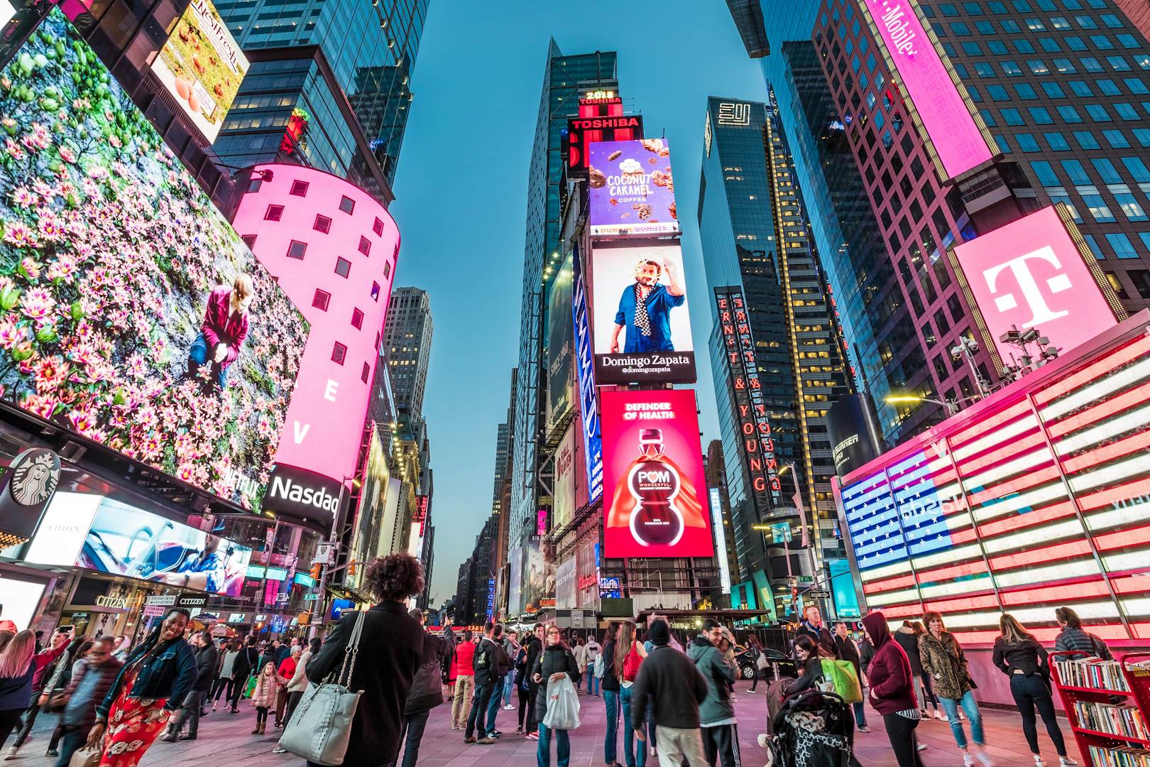 APRIL 23, 2018: The architecture of Times Square with its neon billboards, stores, and many tourists at dusk.