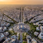 Aerial of Arc de Triomphe in Paris during sunrise.