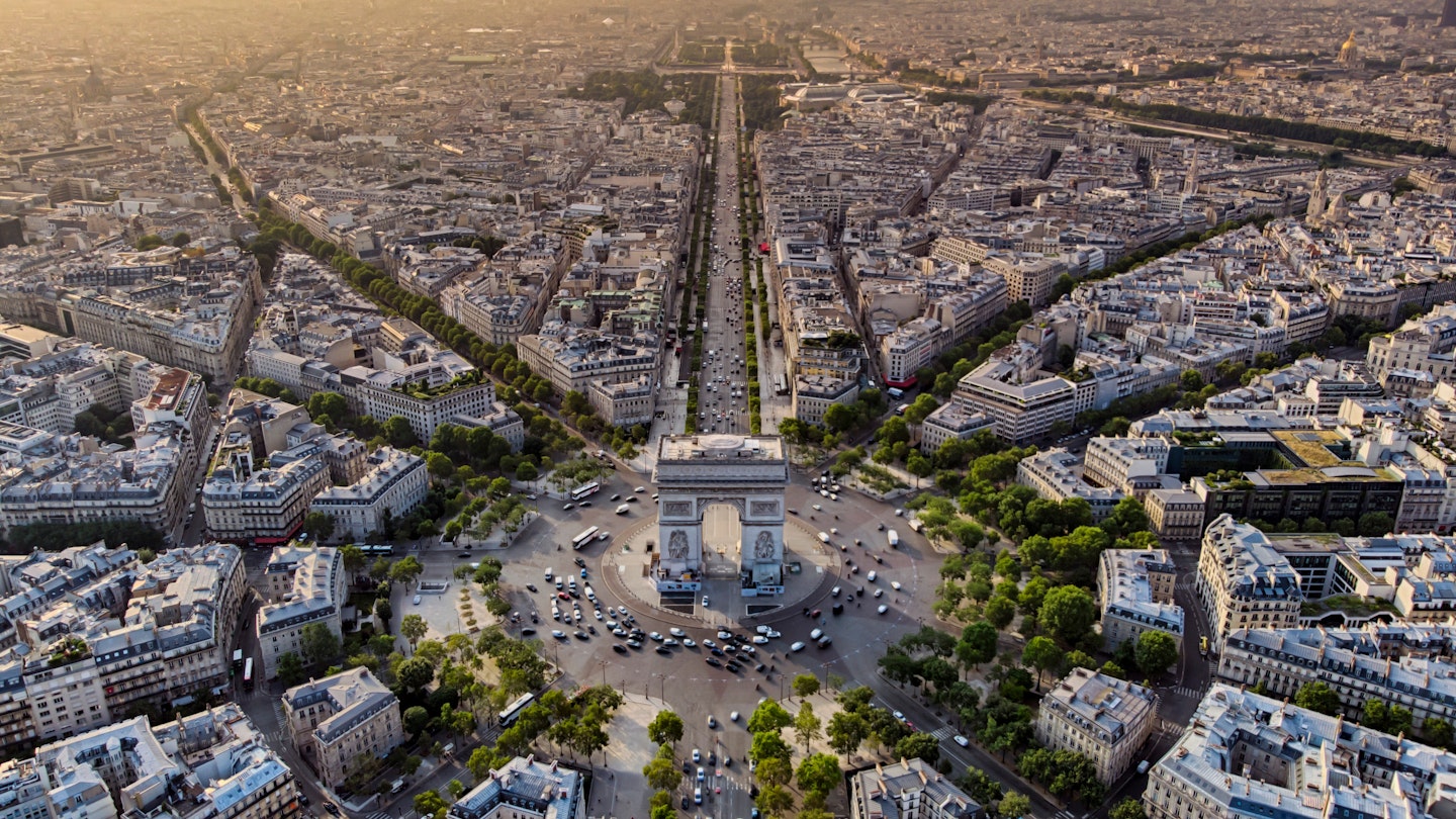 Aerial of Arc de Triomphe in Paris during sunrise.