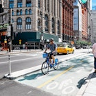 June 20, 2018: Cyclist riding in a bike lane at the Park Row financial district.