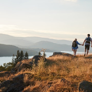 Couple walking hand-in-hand on a path in the Lake District.