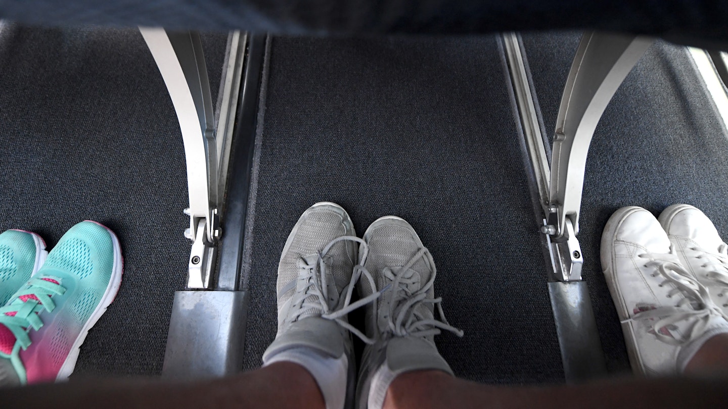 Interior view of a commercial airplane and its legroom in between seats.