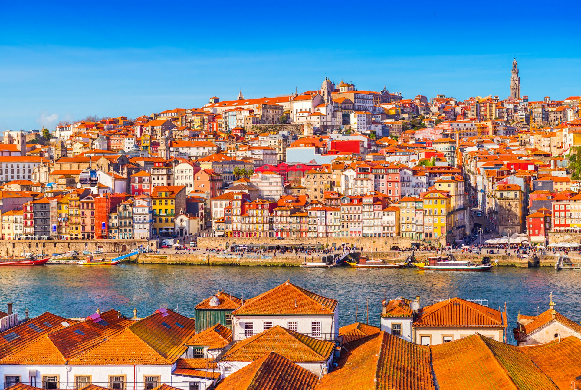 A panoramic view of the old city centre of Porto in Portugal, with scenic old buildings lining the river.