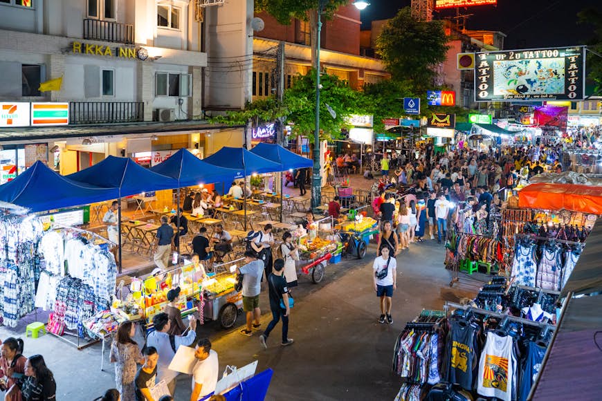 Food, singlets and drinks are being sold at the Khao San Road night market with tourists and locals mingling in amongst the stalls. 